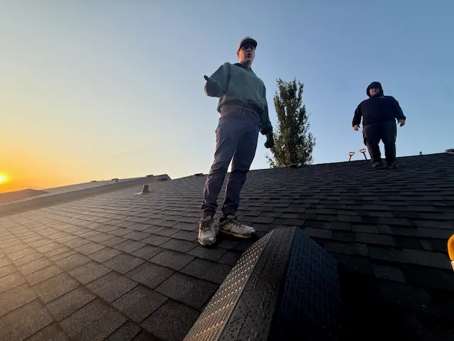 Roof Rangers crew on a shingled roof at sunset in Calgary